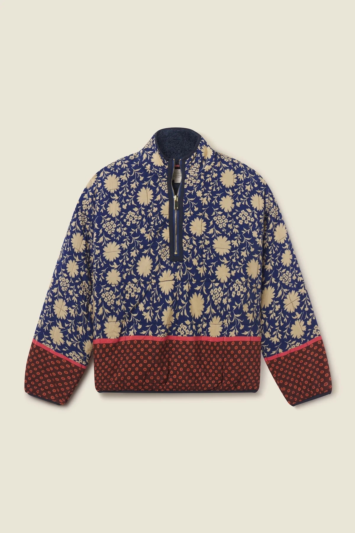 A quarter-zip jacket featuring a navy blue and beige floral pattern on the upper body, with a solid dark red patterned hem and cuffs, and a dark navy collar, shown flat on a light beige background.