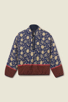A quarter-zip jacket featuring a navy blue and beige floral pattern on the upper body, with a solid dark red patterned hem and cuffs, and a dark navy collar, shown flat on a light beige background.