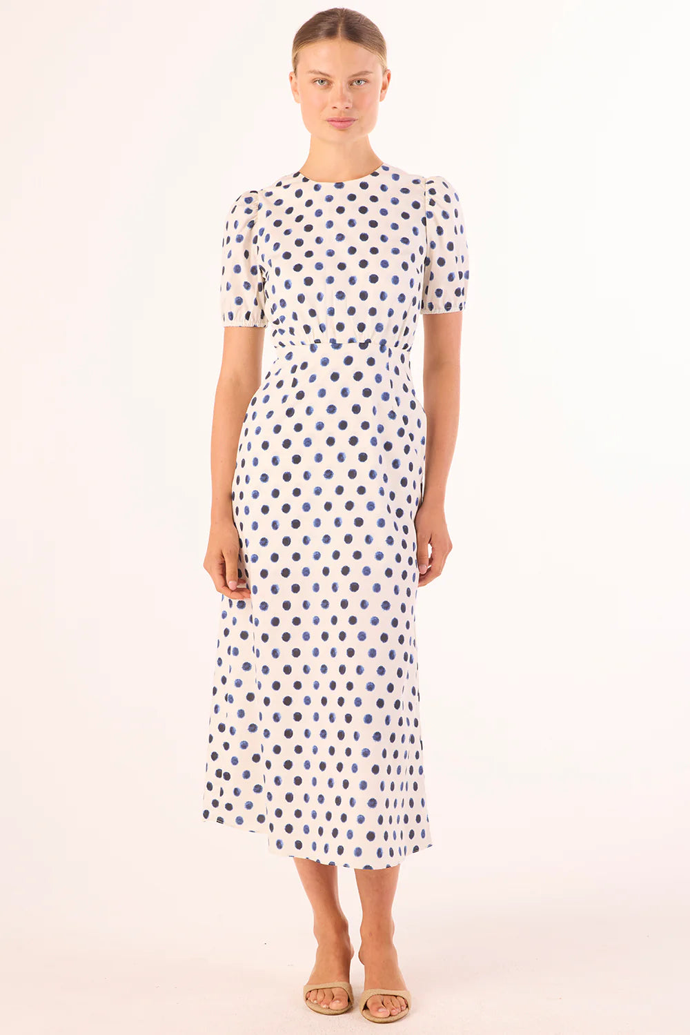 Woman wearing a polka dot dress on a white background