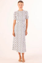 Woman wearing a polka dot dress on a white background