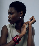 Woman wearing a red bracelet on a gray background