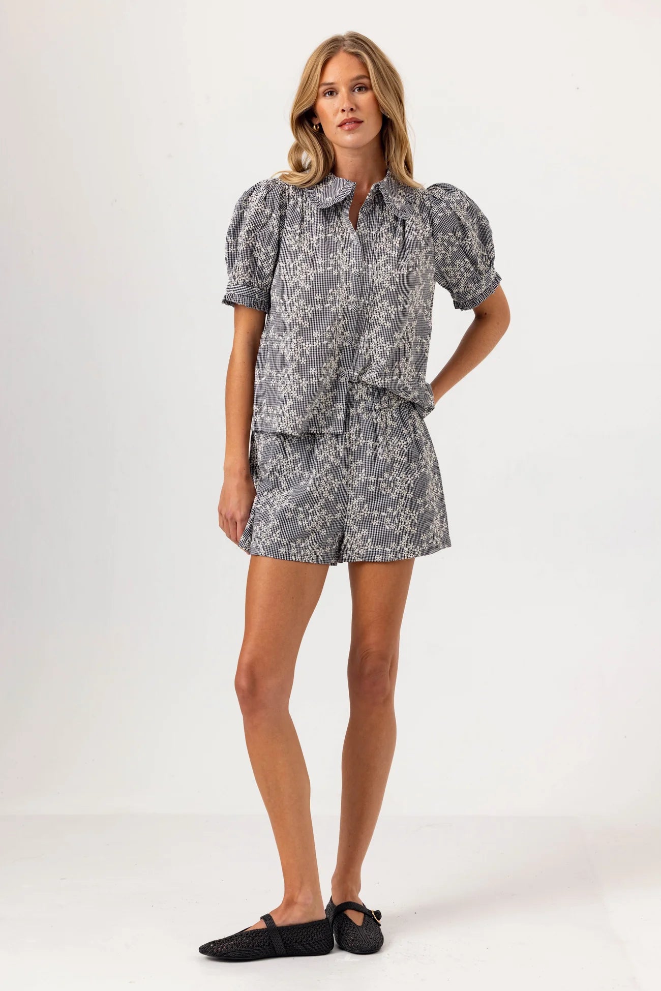 Woman wearing a gray floral dress on a white background