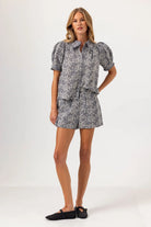 Woman wearing a gray floral dress on a white background