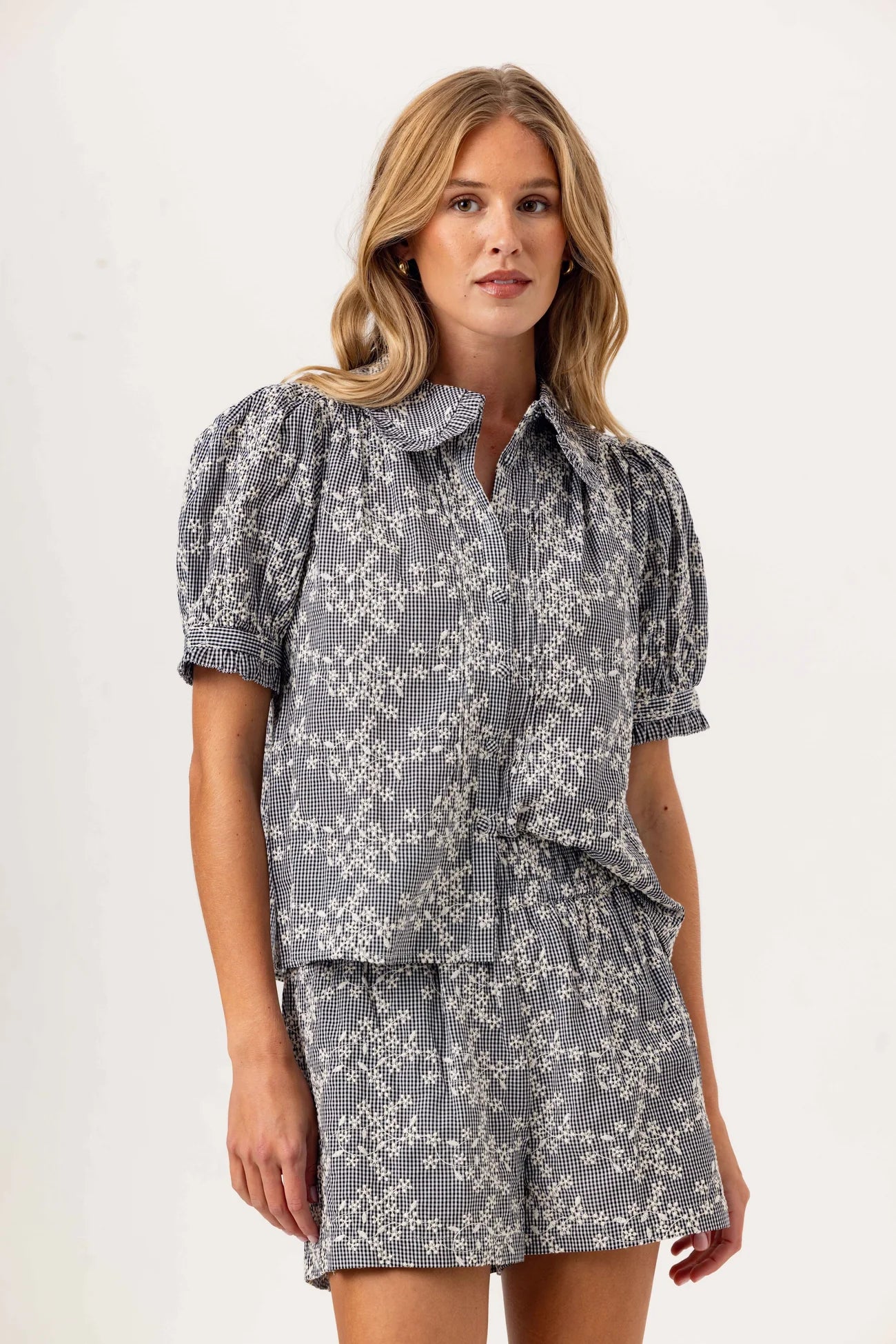 Woman wearing a gray floral dress on a white background