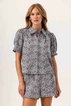 Woman wearing a gray floral outfit on a white background