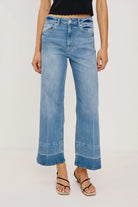 Person wearing blue jeans on a plain background