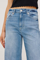 Light blue jeans worn by a person on a plain background