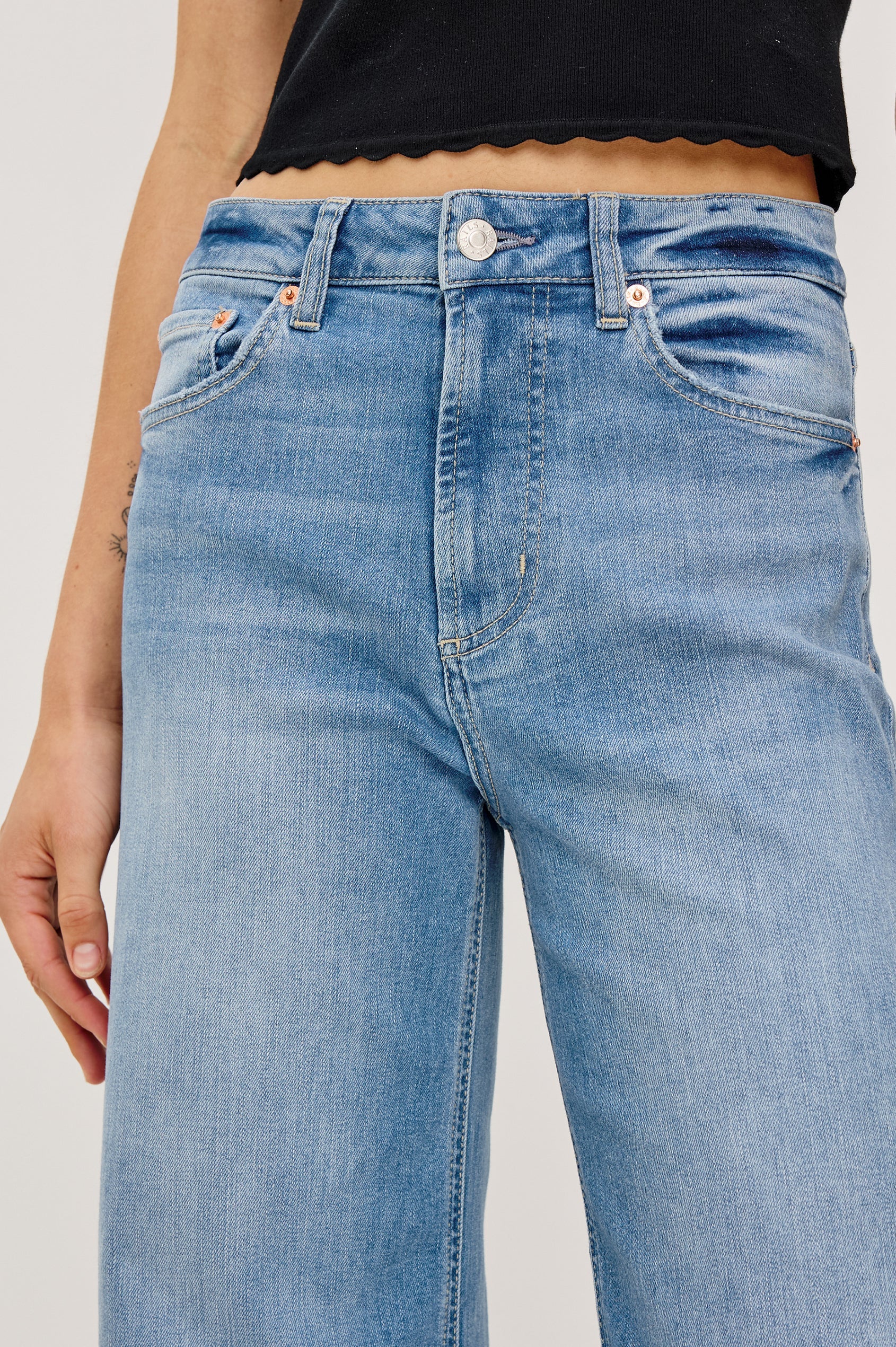 Light blue jeans worn by a person on a plain background