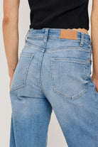 Light blue jeans with a brand logo on a plain background