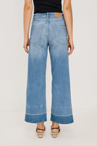 Person wearing blue wide-leg jeans on a plain background