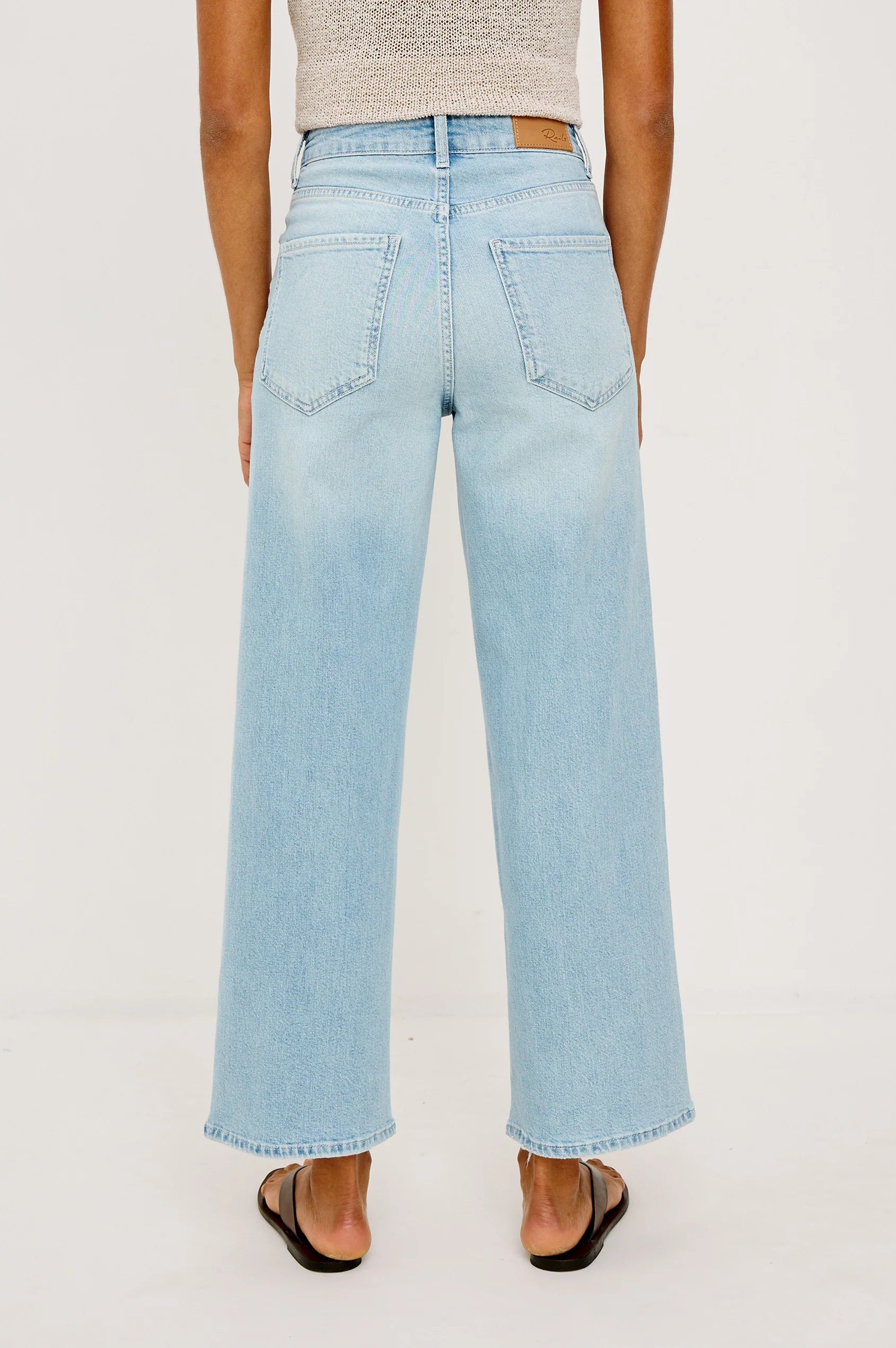 Light blue jeans worn by a person on a white background