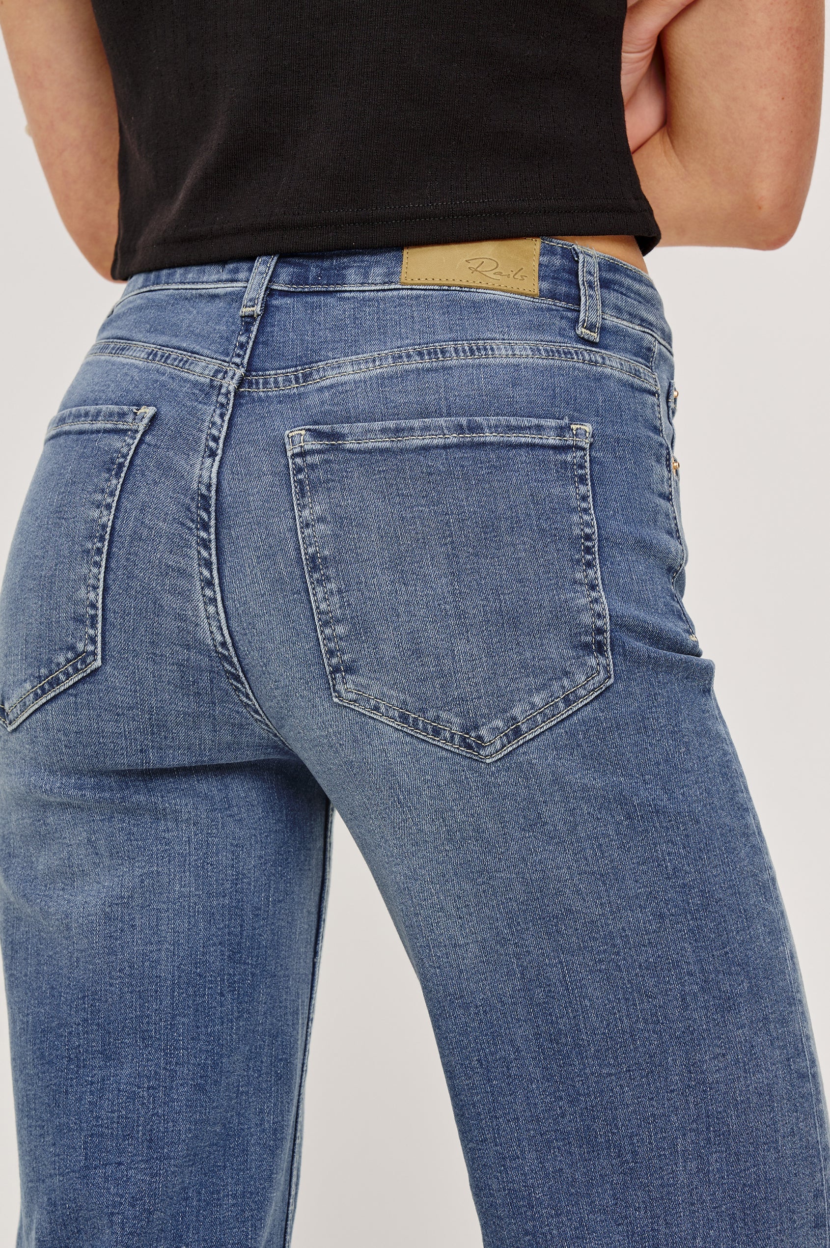 Blue jeans with a visible brand label on a plain background