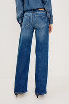 Blue jeans worn by a person on a white background
