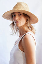 Woman wearing a straw hat against a white background