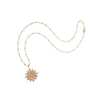 Gold necklace with a decorative pendant on a white background