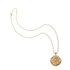Gold necklace with a decorative pendant on a white background