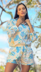 Woman wearing a floral outfit with a blurred natural background