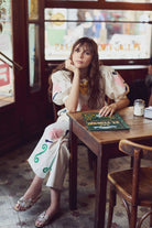 Woman sitting at a table in a cafe with a menu in front of her