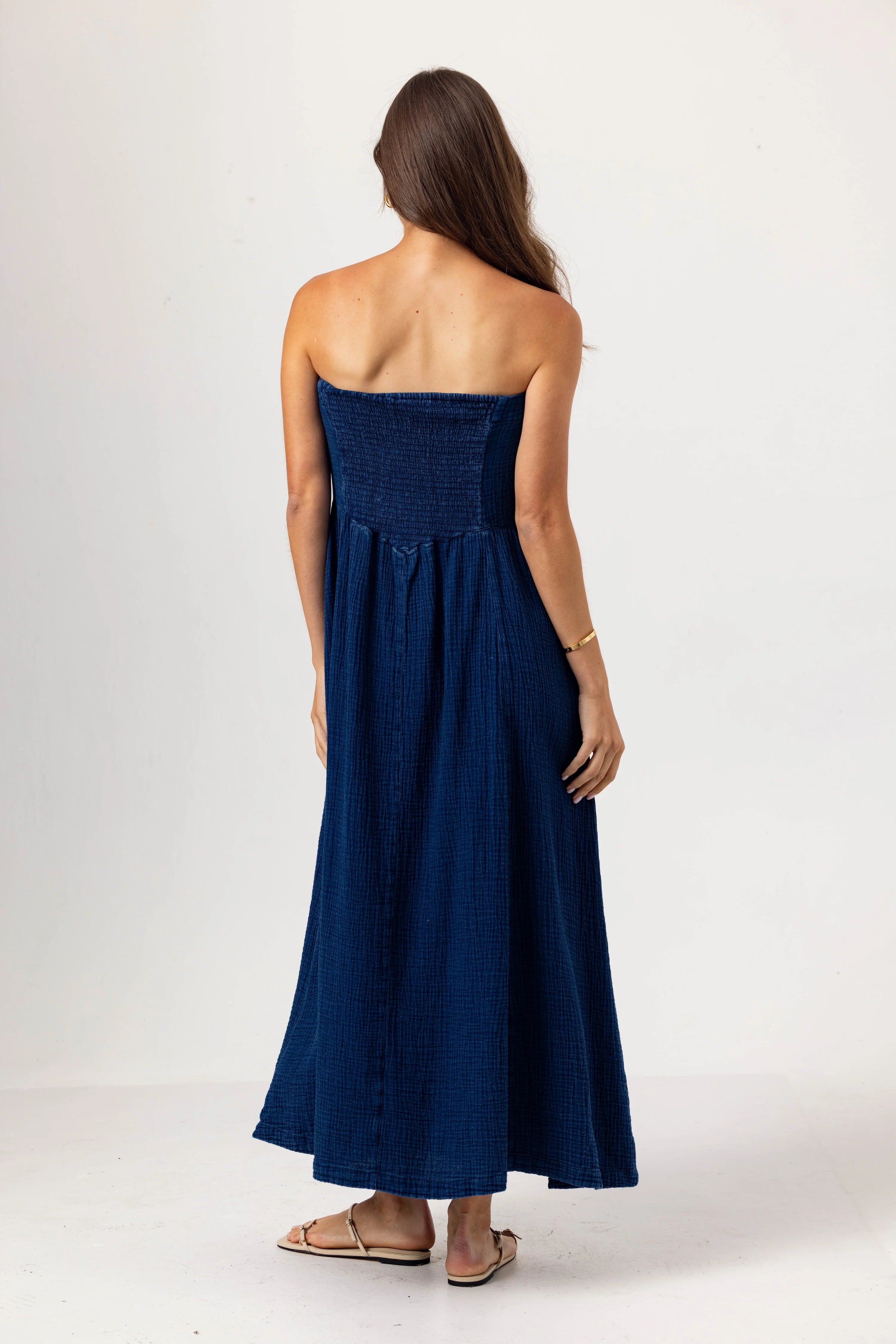 Woman wearing a strapless blue dress on a white background