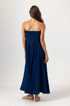 Woman wearing a strapless blue dress on a white background