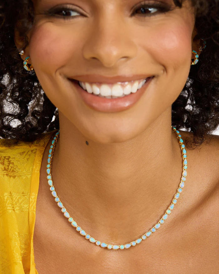 Woman wearing a necklace with a close-up of her face and jewelry.