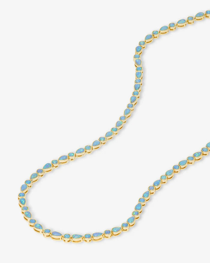 Gold necklace with blue stones on a white background