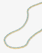 Gold necklace with blue stones on a white background