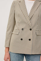 Plaid blazer with black buttons on a plain background