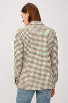 Person wearing a checkered blazer on a plain background