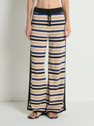Striped pants worn by a person on a plain background