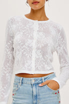 White lace long-sleeve top worn by a person with a white background