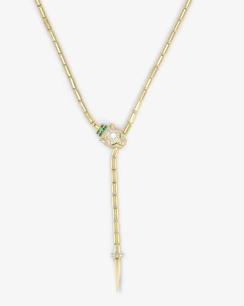 Gold necklace with a pendant featuring green and clear gemstones on a white background