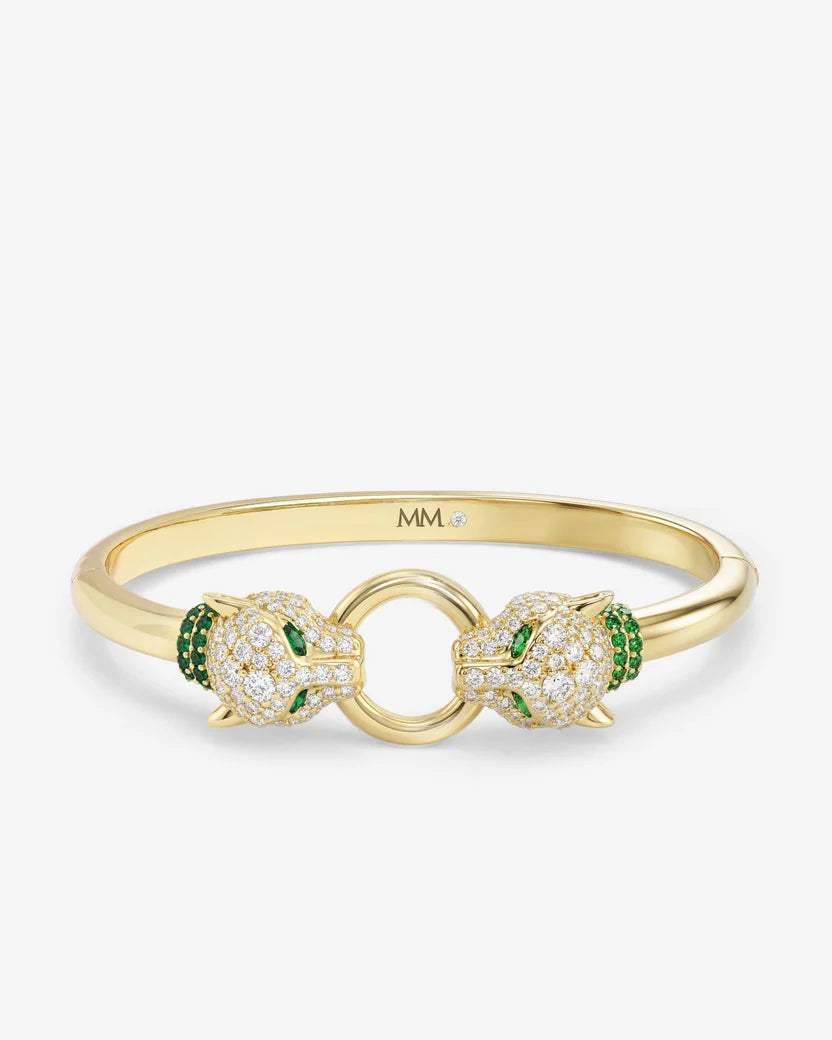 Gold bracelet with green gemstones on a white background
