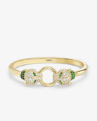 Gold bracelet with green gemstones on a white background