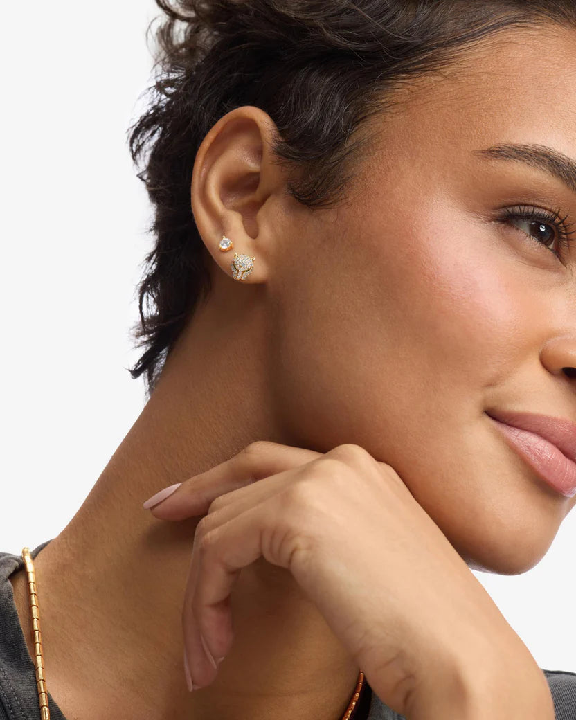 Close-up of a woman wearing a star-shaped earring with a neutral background