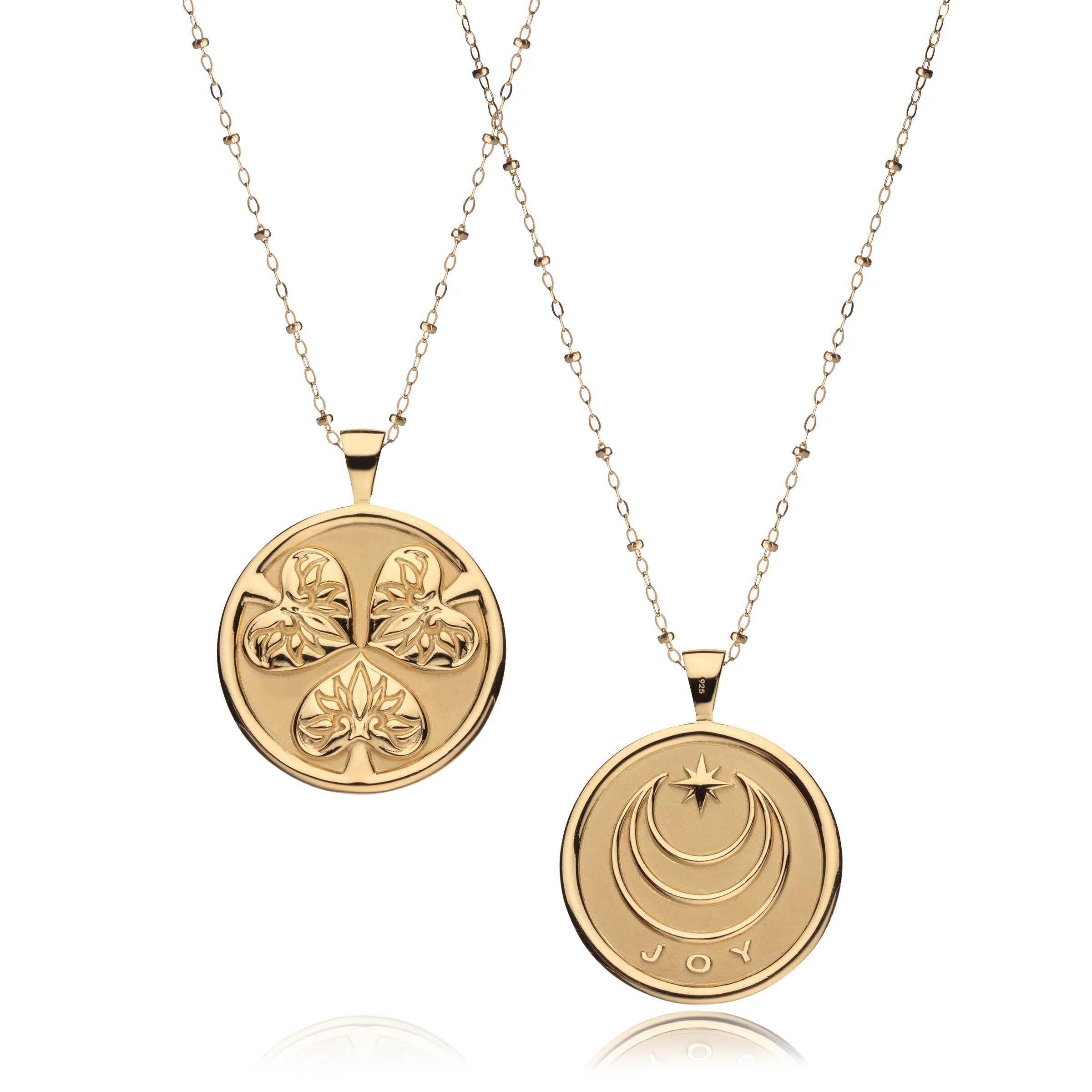 Two gold pendants on chains against a white background