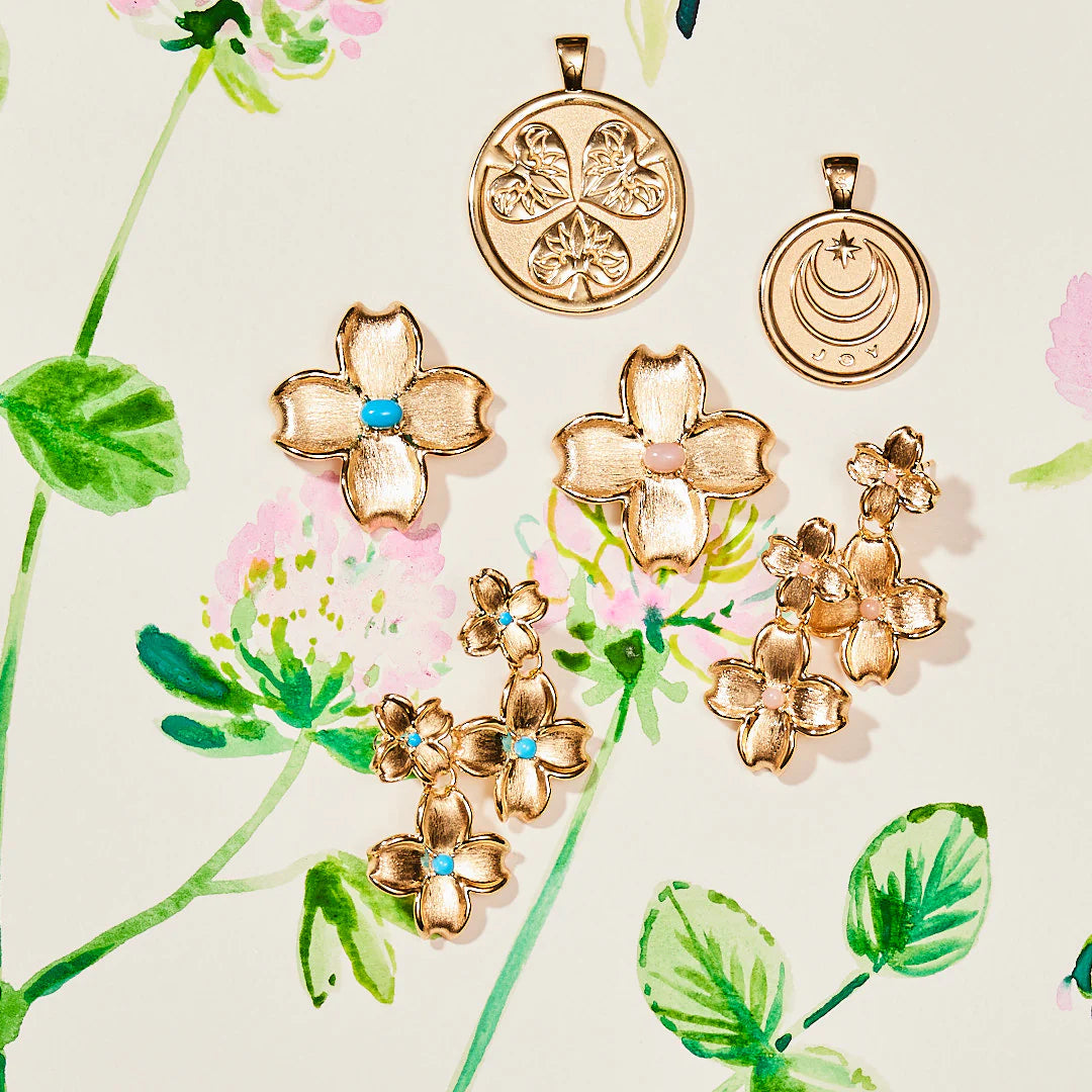 Gold floral earrings and pendants on a floral background