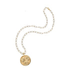 Gold necklace with a round pendant on a white background