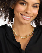 Woman wearing a gold chain necklace with a white background