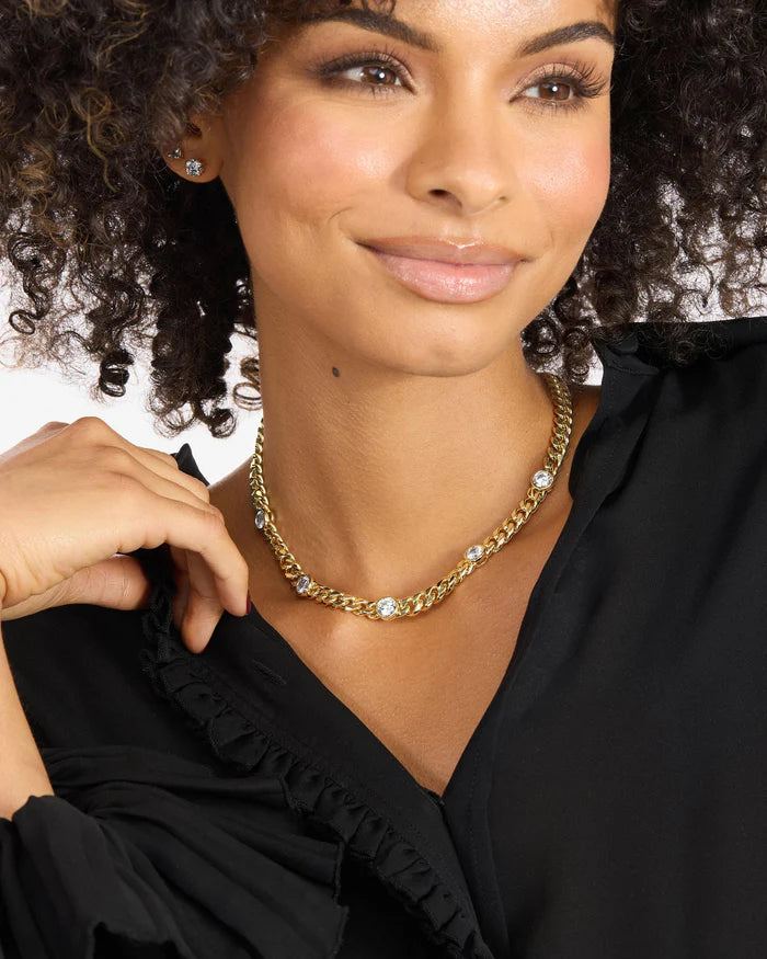 Woman wearing a gold necklace with a blurred background
