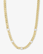 Gold chain necklace with diamond accents on a white background