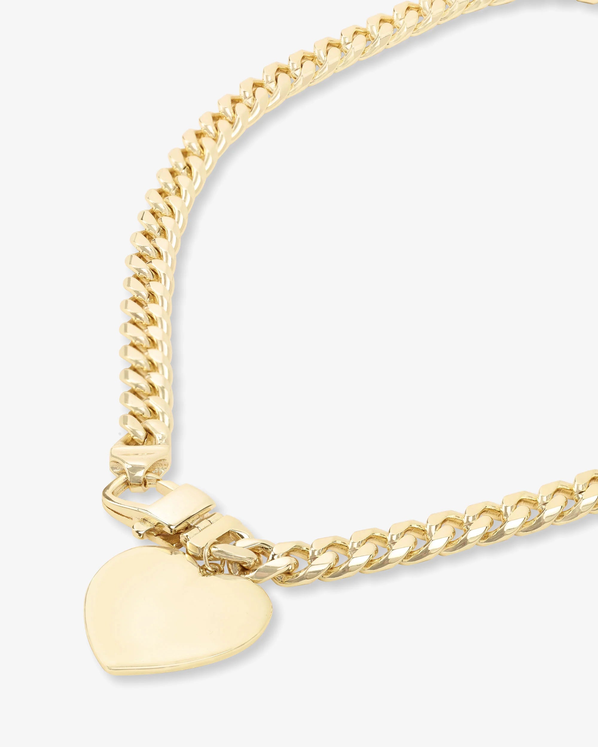Gold chain bracelet with a heart-shaped tag on a light gray background