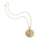 Gold necklace with a circular pendant featuring blue and green stones on a white background