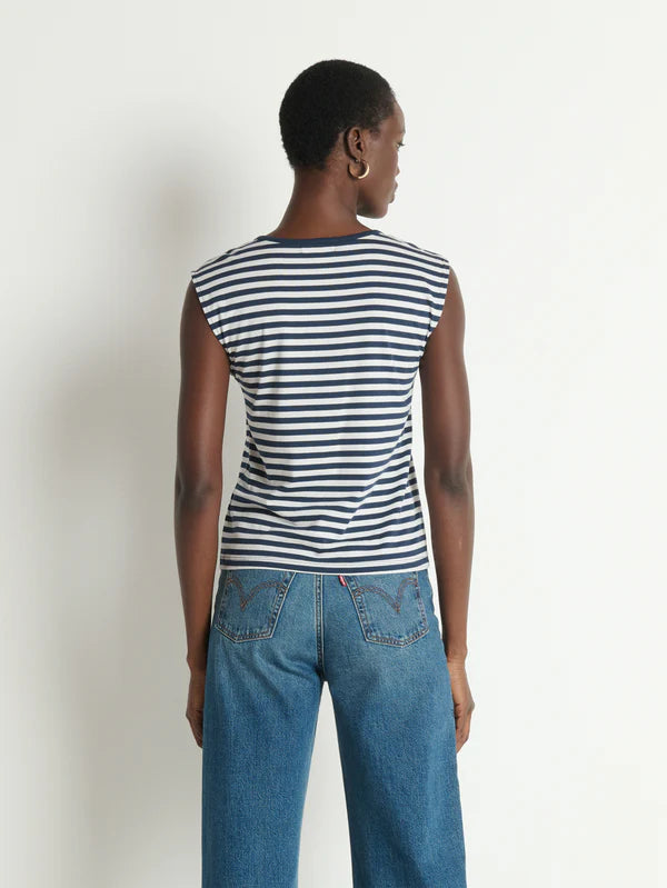 Person wearing a striped shirt and jeans against a plain background