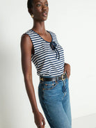 Woman wearing a striped top and blue jeans on a white background