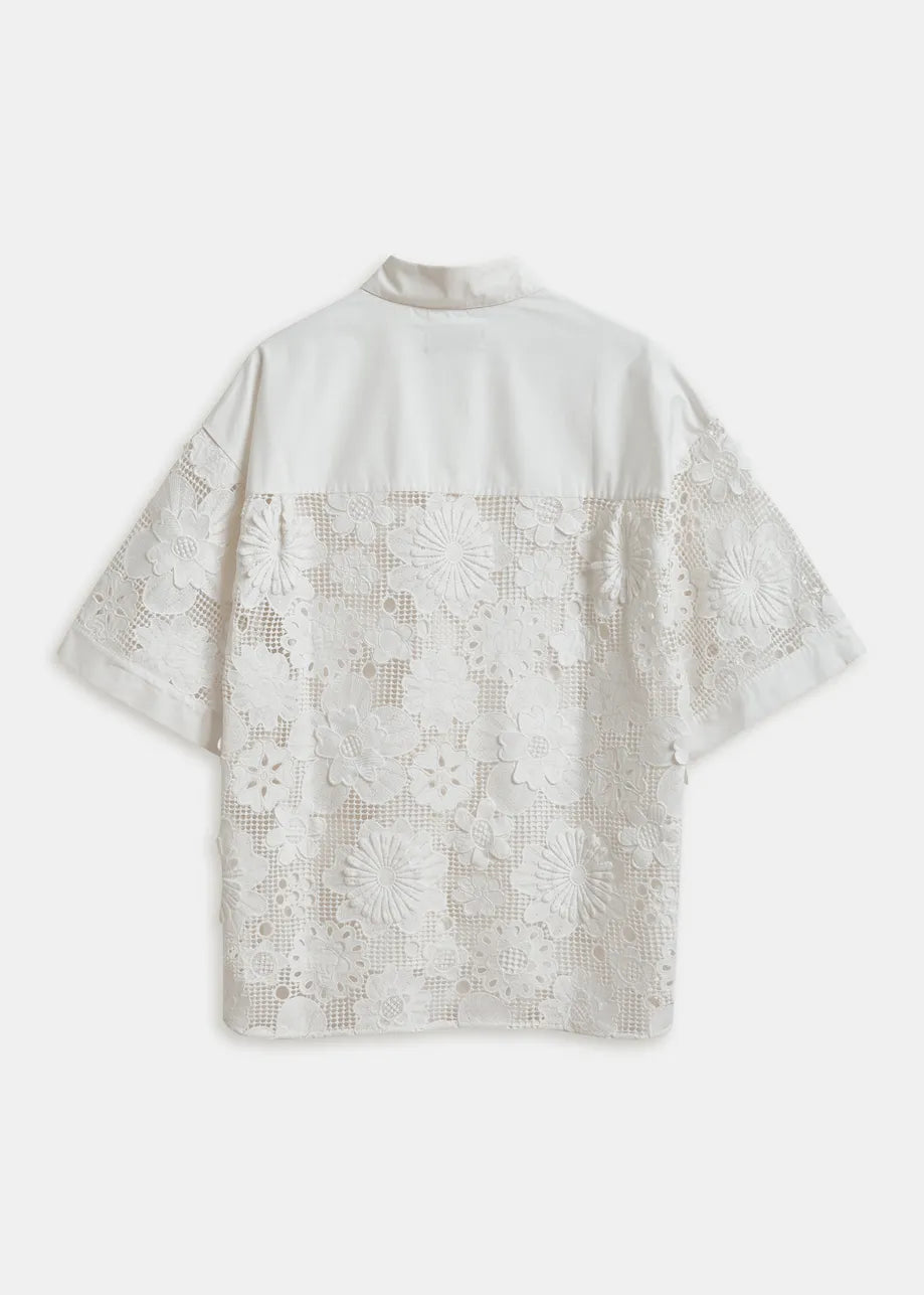 Back view of a white blouse with lace sleeves and back panel on a white background