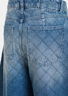 Close-up of blue jeans with a brand label on the pocket.