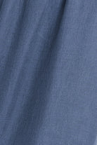 A close-up of blue fabric with a fine textured weave and soft folds.