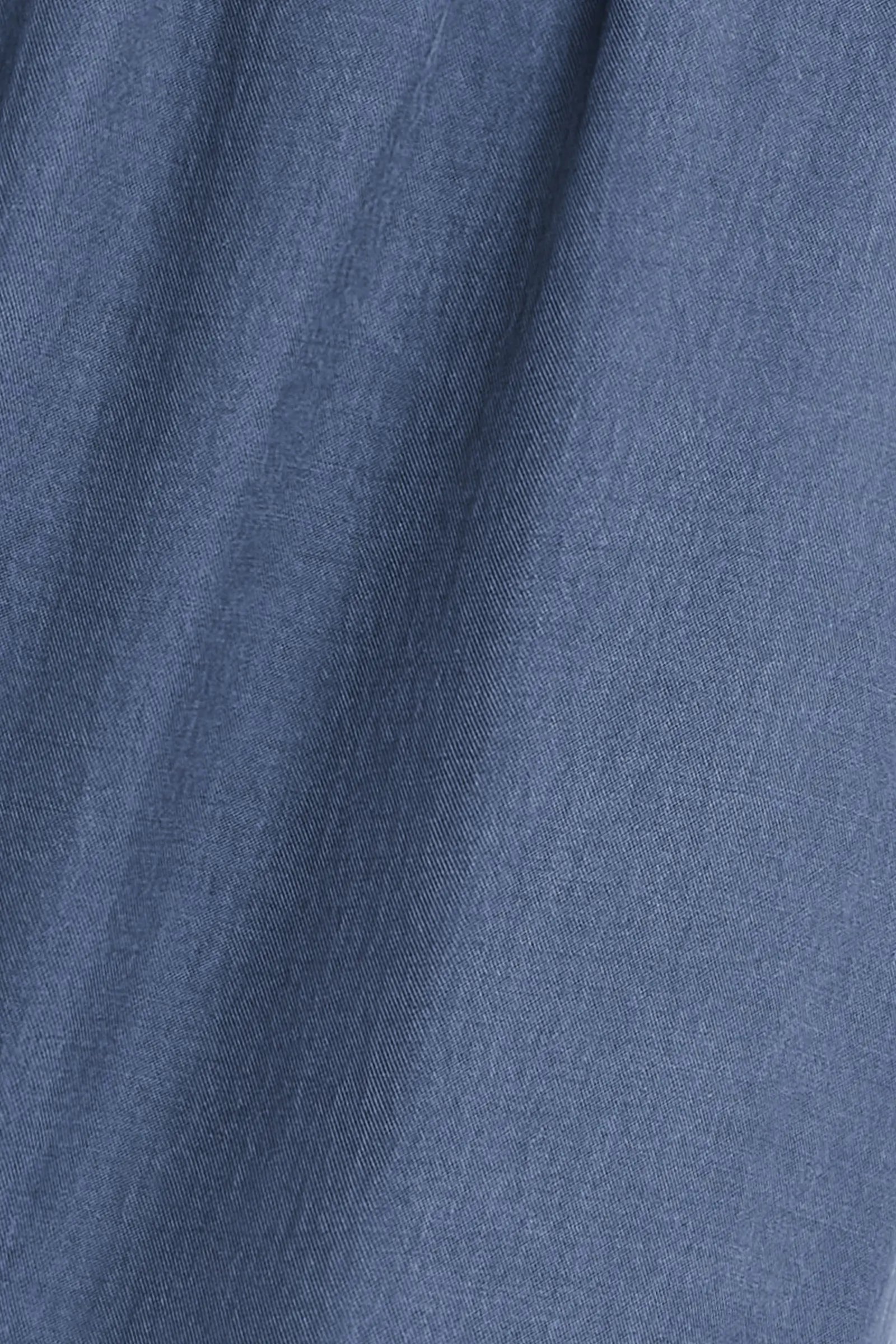 A close-up of blue fabric with a fine textured weave and soft folds.