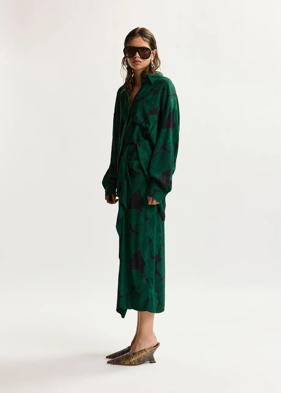Woman wearing a green patterned dress on a white background